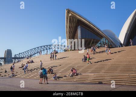 Sydney, Australia - 4 gennaio 2018: Turisti e visitatori si riuniscono sui gradini di fronte all'architettura unica e moderna dell'iconica Sydney Oper Foto Stock