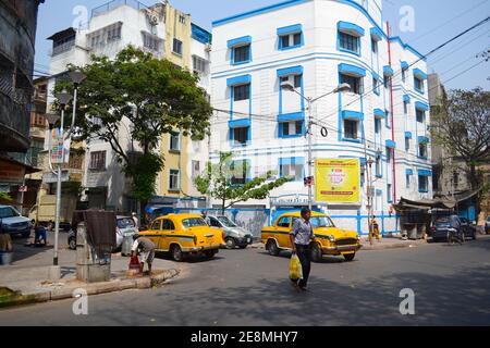 Kolkata, India - Marzo, 2014: Taxi gialli sulla strada. Tradizionali vecchie auto in taxi nel quartiere storico di Calcutta. Uomo che attraversa la strada. Foto Stock