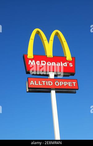 Sodertalje, Svezia - 31 gennaio 2021: Il cartello McDonalds all'esterno del ristorante hamburger con un ulteriore cartello aperto in svedese contro una b Foto Stock