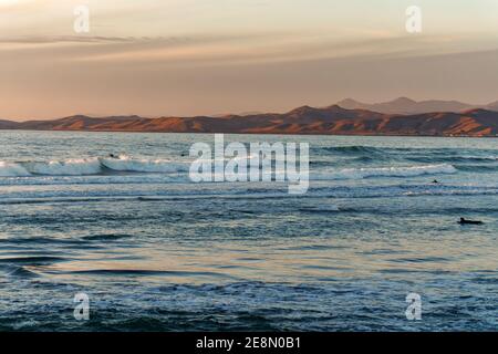 Vista sull'oceano al tramonto, sulle montagne e sul cielo nuvoloso sullo sfondo. Morro Bay, California Central Coast Foto Stock