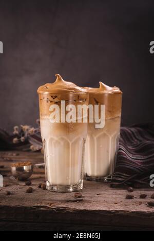 Caffè Dalgona. Bevanda ghiacciata montata con caffè istantaneo popolare in Corea cocktail cremoso in bicchieri alti. Fotografia di cibo con moody scuro Foto Stock