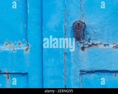 Porta blu in metallo nella parete dell'edificio. Dettaglio del sistema di bloccaggio. Lamiera industrila porta. Foto Stock