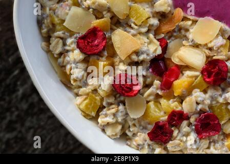 Porridge con semi di chia, mandorle, pezzi d'arancia e frutta, piatto da vicino Foto Stock