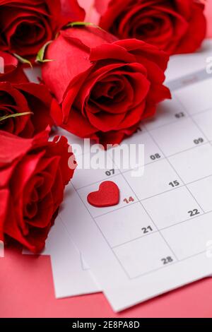 San Valentino. Cuori e rose rosse sulla pagina Calendario. 14 febbraio di San Valentino. Sfondo rosa. Foto Stock