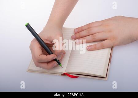 Mano umana che usa la penna per scrivere una breve nota notebook Foto Stock