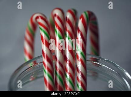 Dolci natalizi, canne caramelle confezionate in plastica in un vaso di vetro trasparente Foto Stock