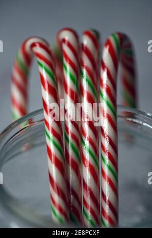 Dolci natalizi, canne caramelle confezionate in plastica in un vaso di vetro trasparente Foto Stock