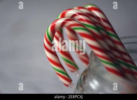 Dolci natalizi, canne caramelle confezionate in plastica in un vaso di vetro trasparente Foto Stock