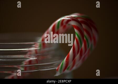 Dolci natalizi, canne caramelle confezionate in plastica in un vaso di vetro trasparente Foto Stock