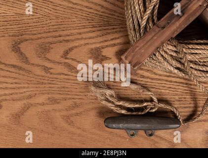 Sfondo con bobina vintage in corda e tacchetto su un disposto su una superficie di legno con spazio per il testo sul lato sinistro. La saturazione è stata ridotta. Foto Stock