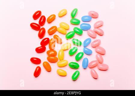 Fagioli di gelatina di arcobaleno dolce su sfondo rosa. Vista dall'alto Foto Stock