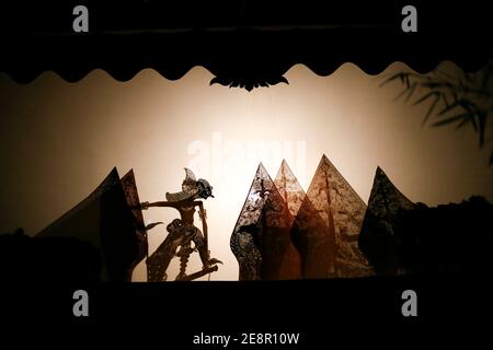 Marionetta indonesiana chiamata wayang kulit che si esibisce sullo schermo di notte Foto Stock