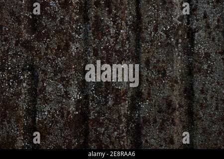 Superficie con ampie strisce arrugginite di macchie marroni uniformi e schizzi d'argento su sfondo grigio acciaio con scanalature verticali. Foto Stock
