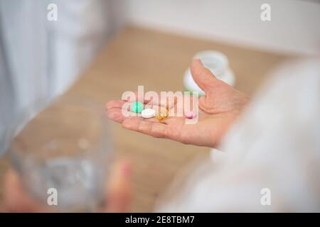 Primo piano immagine della mano womans con pillole su di esso Foto Stock