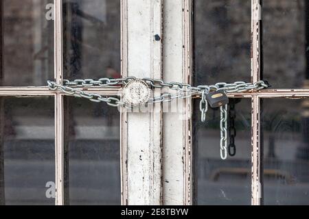 Ferro serratura e catena su una vecchia porta arrugginita Foto Stock