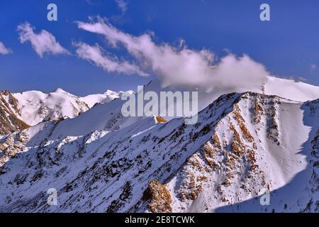 Epica vista serale di una valle di montagna dopo una nevicata; la prima neve in montagna con l'avvicinarsi della stagione invernale Foto Stock