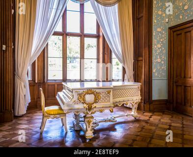 ALUPKA, RUSSIA - 04 MAGGIO 2009: Grande pianoforte bianco decorato con bassorilievo dorato nel soggiorno in stile vittoriano nel Palazzo Vorontsov, costruito in Foto Stock