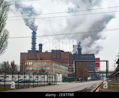 Il fumo denso e denso proviene dai tubi industriali del camino. Tubi con fumo, produzione industriale Foto Stock