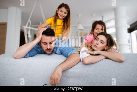 La madre stanca e il padre si sentono seccati mentre rumoroso poco bambini a casa Foto Stock