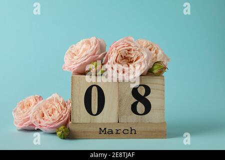 Calendario in legno con 8 marzo e rose su sfondo blu Foto Stock