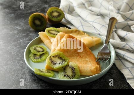 Concetto di deliziosa colazione con crepes con kiwi su nero sfondo smussato Foto Stock