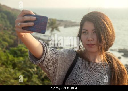 Giovane donna che viaggia intorno alla spiaggia costiera di Goan nella contea dell'India. Foto Stock