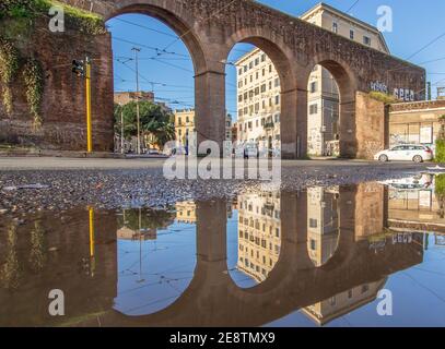 Frequenti docce a pioggia creano delle piscine in cui il meraviglioso centro storico di Roma si riflette come in uno specchio. Qui in particolare Piazza di porta maggiore Foto Stock