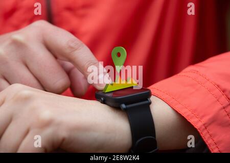 Vista ravvicinata di una persona che controlla il percorso e il suo posizionatevi sul loro smart watch durante un allenamento Foto Stock