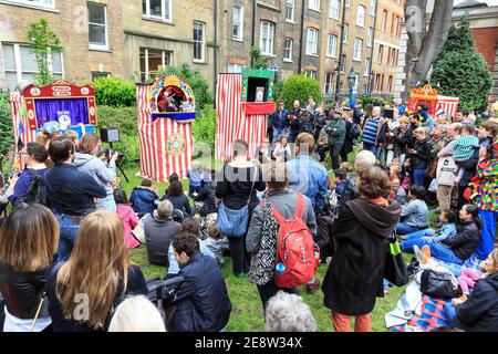 La gente guarda uno spettacolo di Punch and Judy al Covent Garden May Fayre and Puppet Festival, Londra, Regno Unito Foto Stock