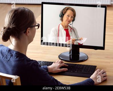 Immagine simbolica di telemedicina, paziente parla con un medico in una videoconferenza, da casa, Foto Stock