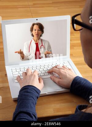 Immagine simbolica di telemedicina, paziente parla con un medico in una videoconferenza, da casa, Foto Stock