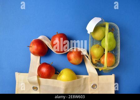 Dettaglio della frutta acquistata in confezione di plastica e riutilizzabile sacchetti di tessuto Foto Stock