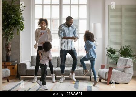 I genitori afroamericani e i bambini che ballano in tutta la loro lunghezza sono stati molto contenti Foto Stock