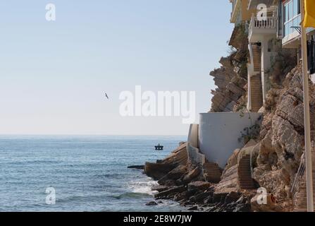 Case residenziali costruite in montagna rocciosa vicino calmo blu Mar Mediterraneo. Città turistica di Benidorm. Provincia di Alicante, Costa Blanca, Spagna Foto Stock