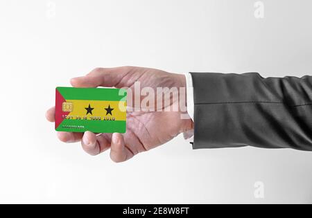 Carta di credito bancario in plastica con bandiera di Sao Tomé e. Principe che tiene l'uomo in un abito elegante Foto Stock