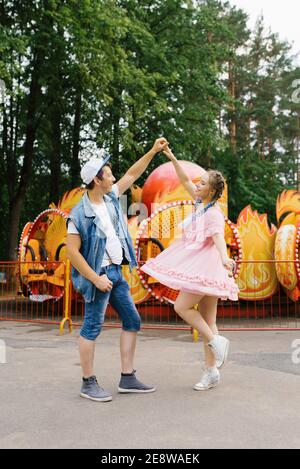 Felice giovane coppia innamorato divertirsi in un divertimento parco e balli Foto Stock