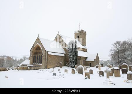 Chiesa di San Marys nella neve. Swinbrook, Cotswolds, Oxfordshire, Inghilterra Foto Stock