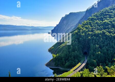 Calmati sul lago Baikal. Vista dall'alto in grande scala del lago Baikal e la sezione della ferrovia Circum-Baikal al portale Irkutsk del tunnel n° 33. Nella b Foto Stock