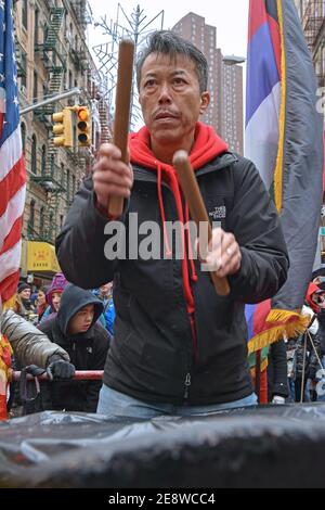 Un uomo cinese americano di mezza età suona la batteria durante le celebrazioni lunari di Capodanno a Chinatown, Manhattan nel 2016. Foto Stock