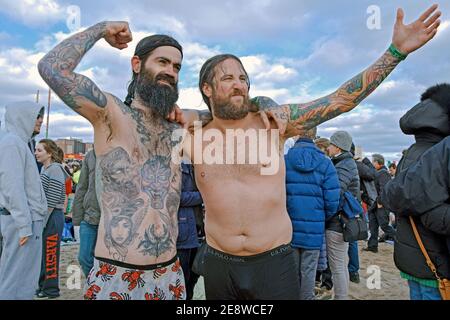 2 nuotatori emergono dall'acqua dopo aver partecipato all'annuale nuotata invernale del Polar Bear Club di Capodanno. A Coney Island, Brooklyn, NY, 2016. Foto Stock