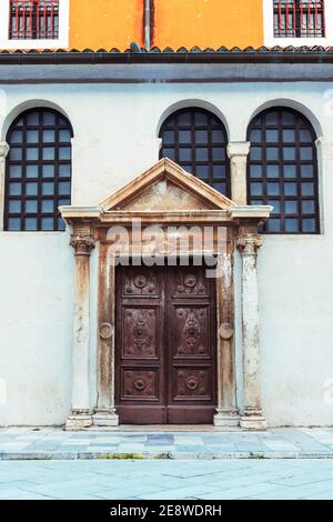 Vecchia porta in legno decorata e frammento di un edificio. Foto Stock