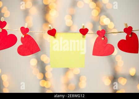 Bianco giallo appeso con cuori rossi con sfondo bokeh, romantico giorno di San Valentino sfondo spazio di copia di concetto Foto Stock