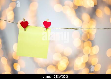 Bianco giallo appeso con cuori rossi con sfondo bokeh, romantico giorno di San Valentino sfondo spazio di copia di concetto Foto Stock
