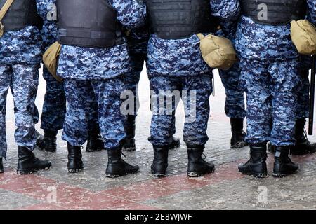 Le gambe dei poliziotti russi in piedi in cordon sul raduno politico a Mosca Foto Stock