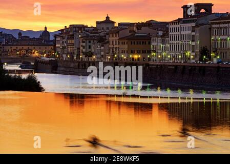 un canoista che si rilassa sull'arno di firenze in prossimità della pescaia di san niccolò al tramonto Foto Stock