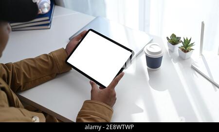 Un'immagine di un giovane che usa un tablet digitale per collegare Internet o la connessione wireless a casa. Foto Stock