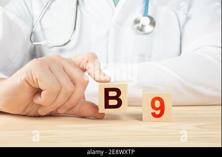 vitamine e minerali essenziali per l'uomo. il medico raccomanda di prendere la vitamina b2. il medico parla dei benefici della vitamina b9. B9 Vitamina - Salute Co Foto Stock