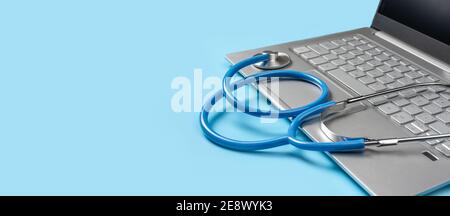 computer portatile pc e stetoscopio medico isolati su sfondo blu. Concetto di telesanità. Consultazione medica online, spazio di copia. Banner Foto Stock