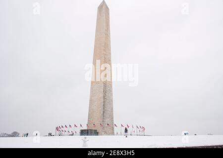 Un simpatico pupazzo di neve sorride ai visitatori di fronte al Washington Monument durante una giornata invernale innevata a Washington, D.C. Foto Stock