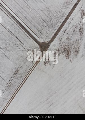 Immagine dall'alto verso il basso dell'intersezione a tre vie tra i campi in zona rurale in inverno con neve Foto Stock